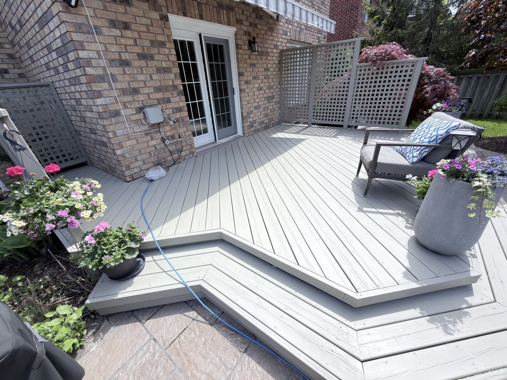 Finished grey deck with seating and flower planters