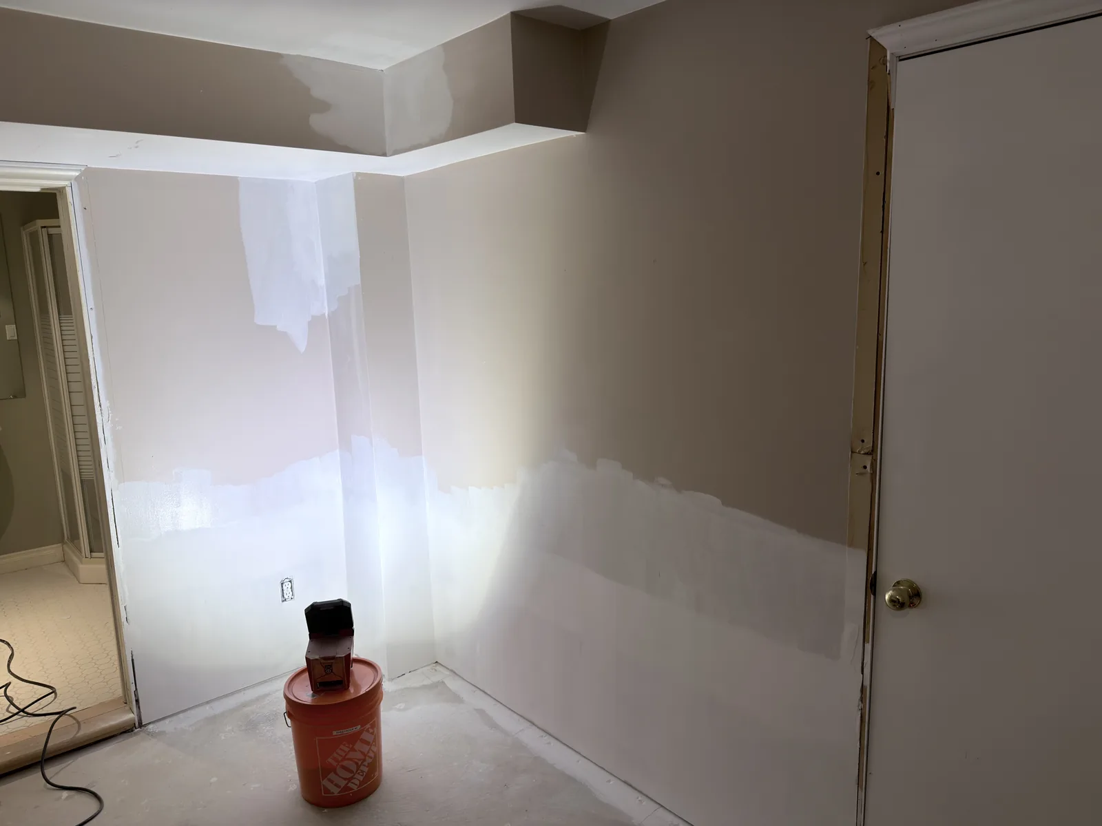Interior wall with patched seams and repair areas beside a doorway