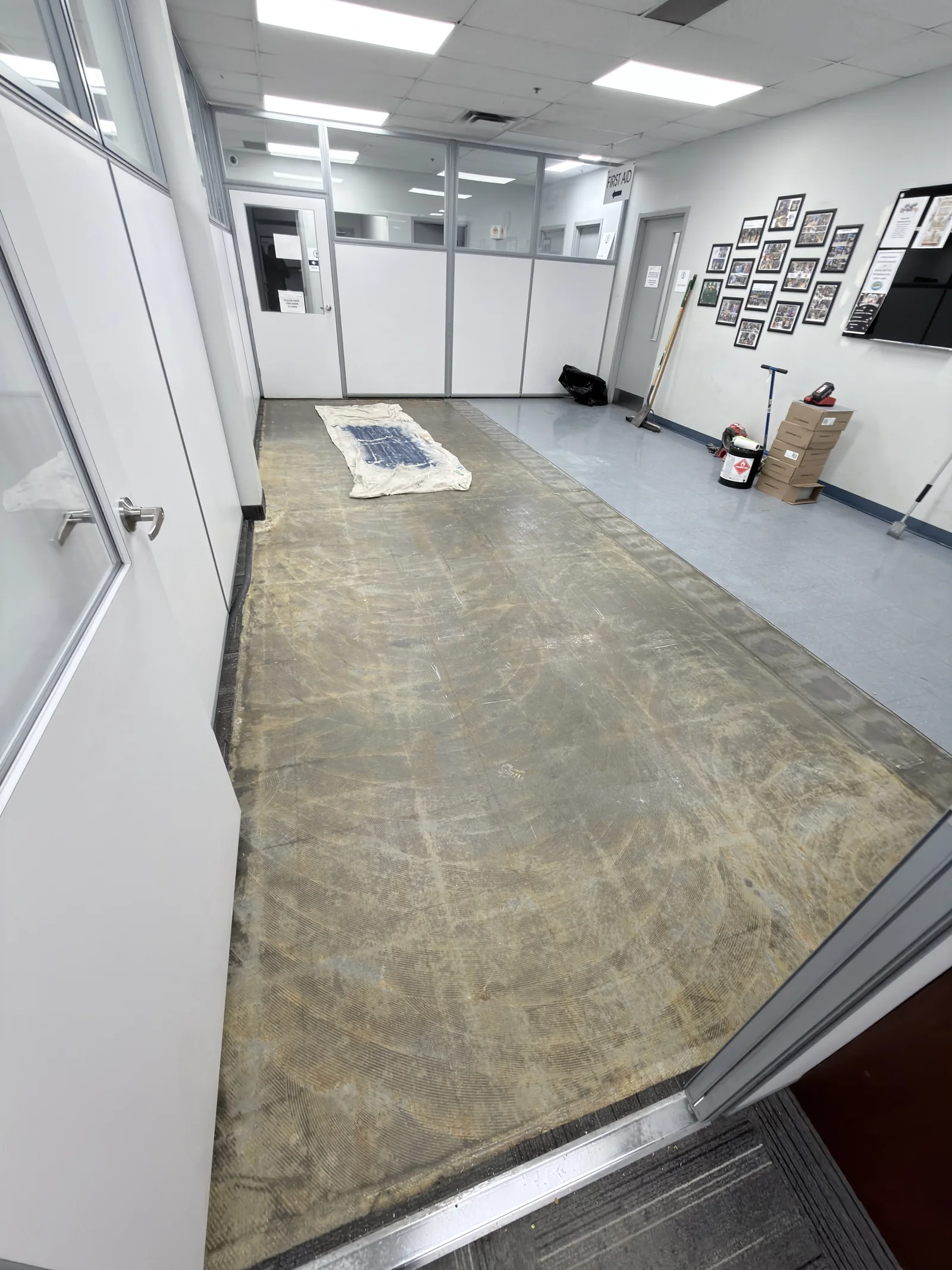 Exposed floor surface in an office after sections of tile have been removed