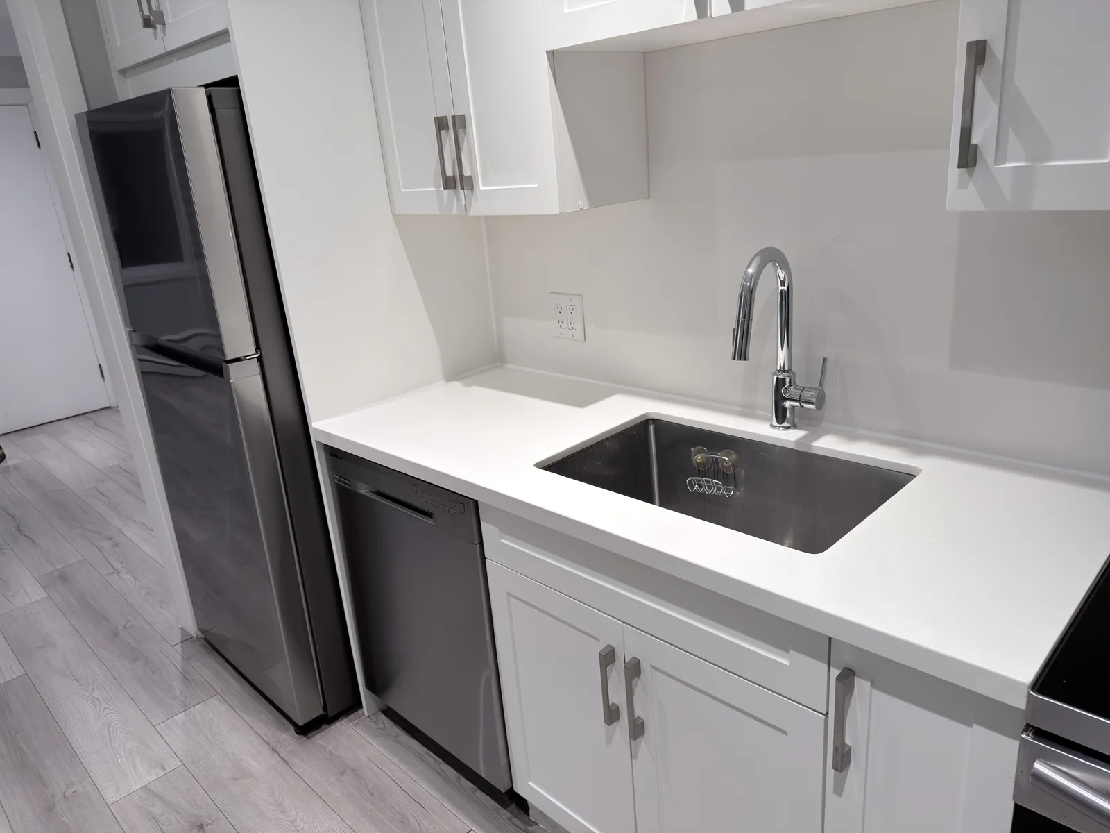 Kitchen counter and sink with sealed joints along the backsplash