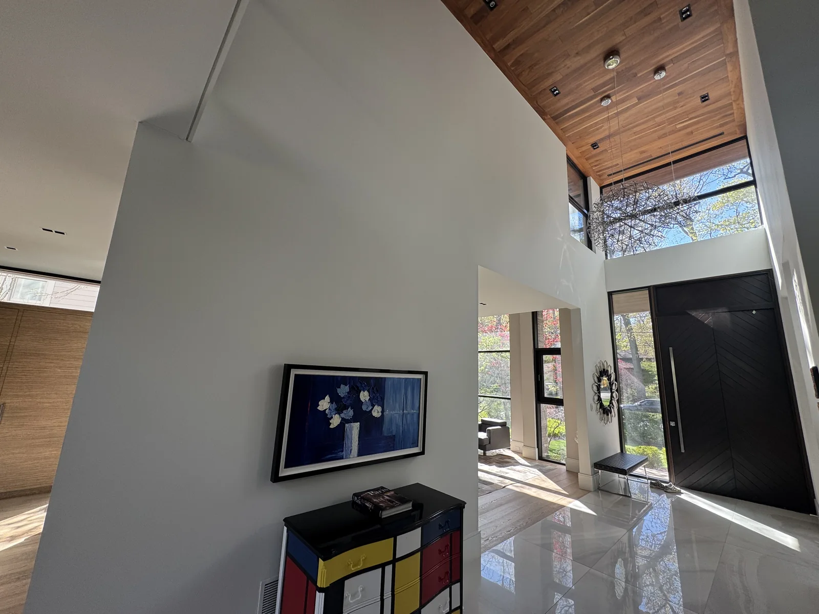 Light-coloured painted walls beside a tall entrance door and wood ceiling